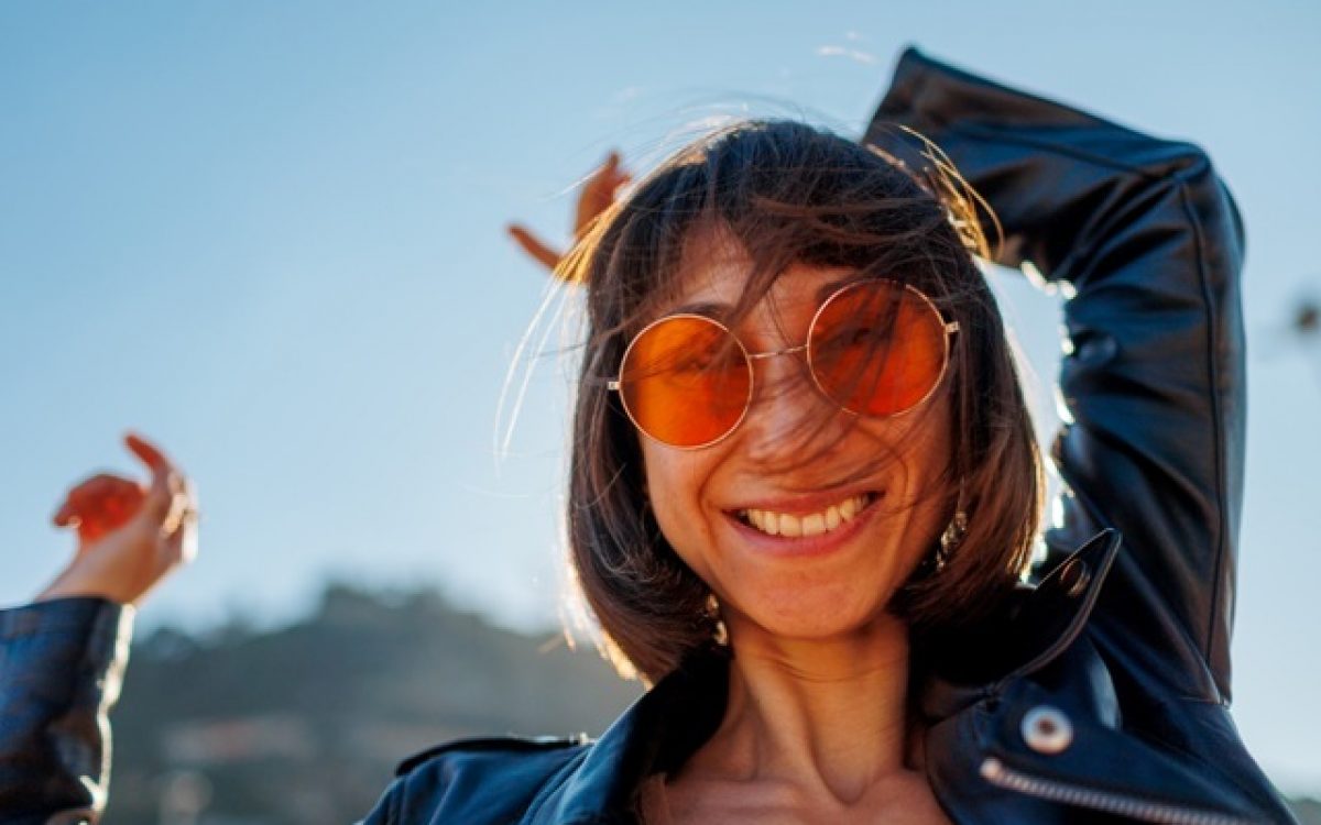 Girl dancing at a rock concert, stylish girl in a leather jacket dancing outdoors, rock music, happy woman in sunglasses.; Shutterstock ID 2591864863; purchase_order: -; job: NATURA COSMÉTICOS S.A.; client: -; other: